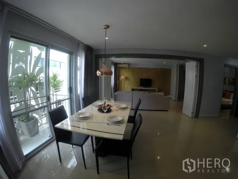 คอนโด ให้เช่าในWatthana, Bangkok - โต๊ะกินข้าวท็อปหินอ่อน พร้อมโคมไฟแขวนสีทองแดง ข้างระเบียงมีต้นไม้