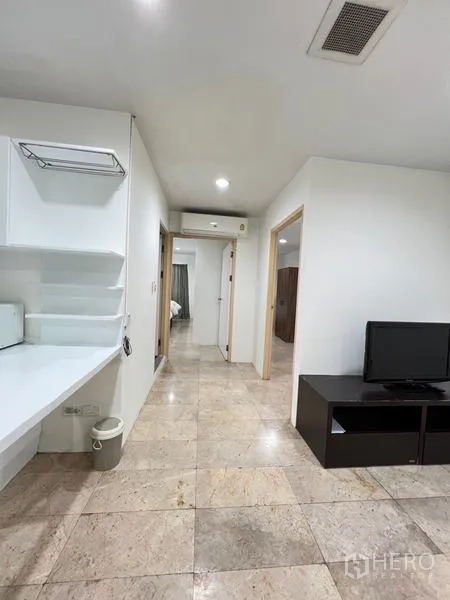 Condominium for rent in Ratchathewi, Bangkok - Open living space with TV stand, breakfast counter and tiled floor.