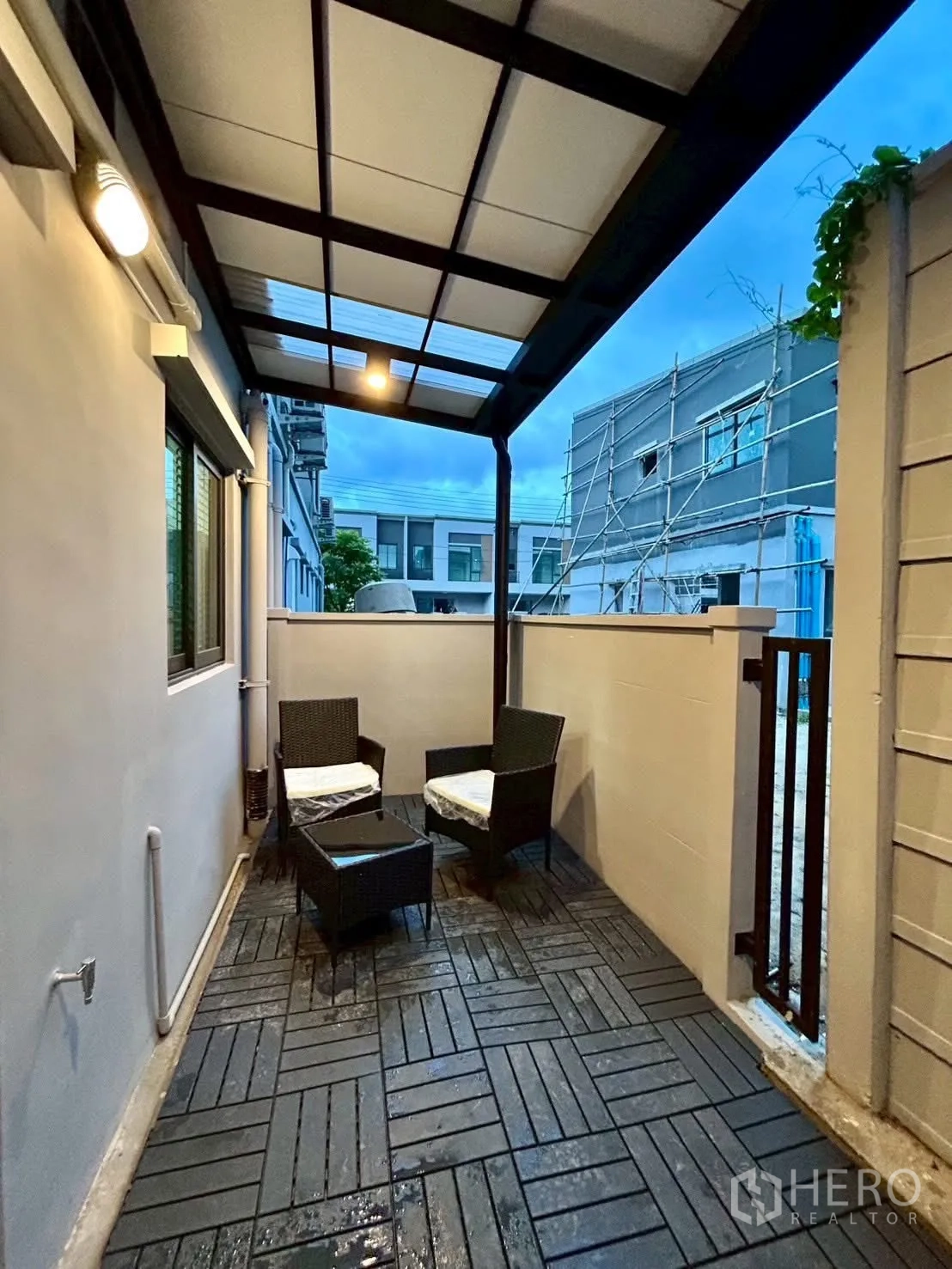 Townhouse for rent in Bang Phli, Samut Prakan - View of sheltered patio with wicker chairs, small table and gate.