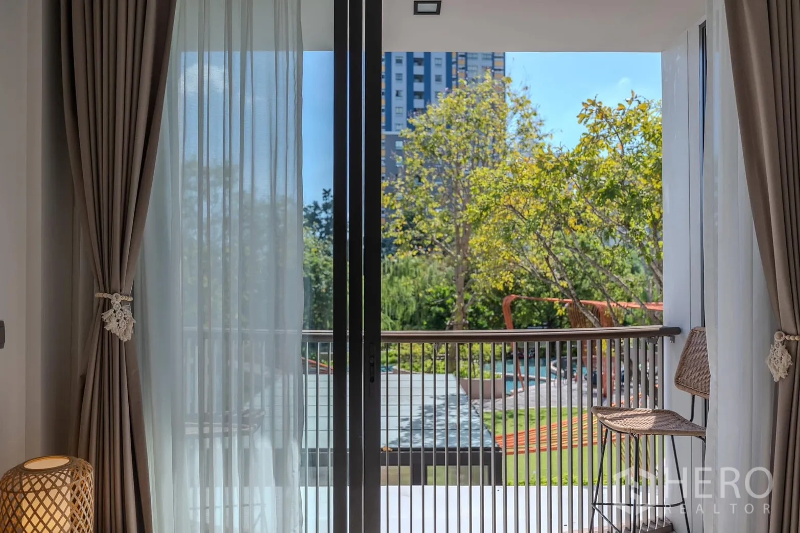 Condominium for rent in Watthana, Bangkok - Private balcony with bar stools overlooking landscaped gardens and the pool.