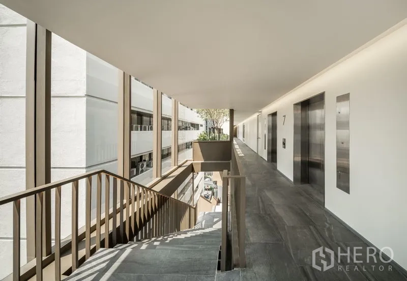 Office Space for rent in Bang Kapi, Bangkok - Open-air corridor with elevators and staircase, featuring abundant natural light.