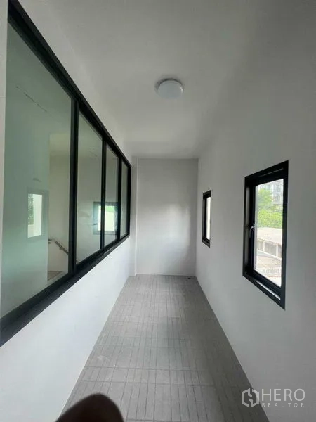 Home Office for sale - Narrow interior corridor with side windows bringing in natural light.