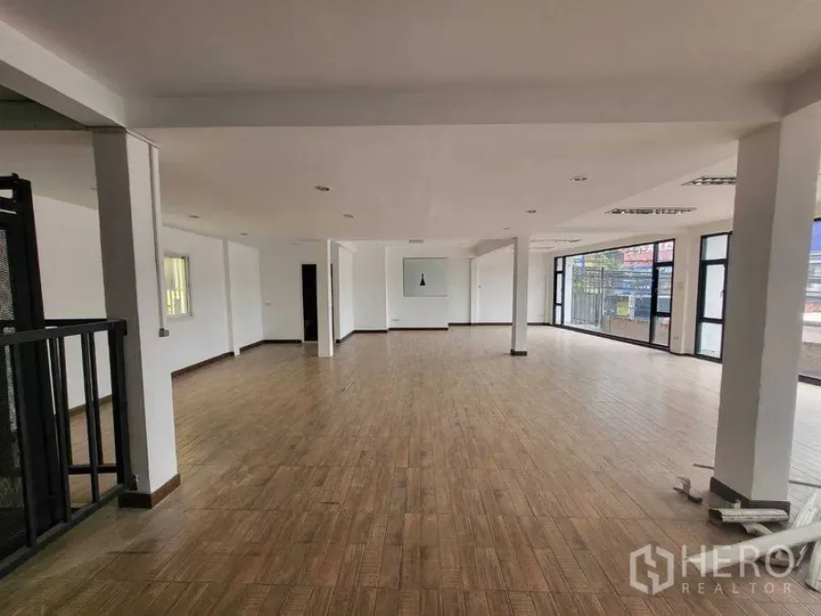 店屋 出租在Khlong Toei, Bangkok - 明亮的上层开放区，落地玻璃与多根立柱，木纹地面。