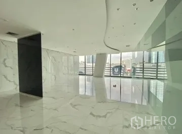Office Space for rent - Bright lobby-style office area with marble-look floors, curved ceiling, glass wall and city skyline views.