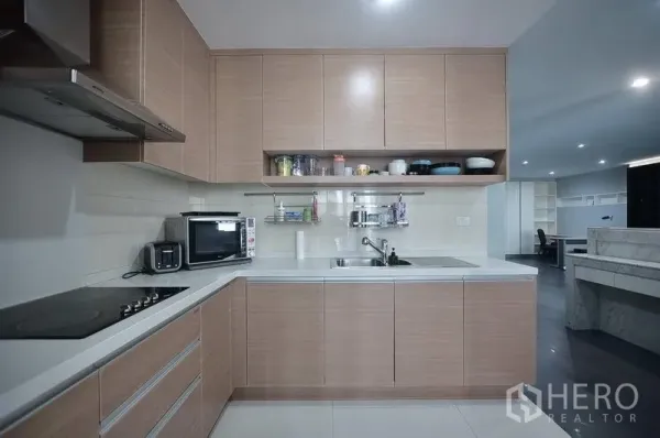 คอนโด ให้เช่าในKhlong Toei, Bangkok - ครัวรูปตัวแอลสมัยใหม่ ตู้บิลท์อิน เตาไฟฟ้า ฮูด ไมโครเวฟ และอ่างล้างจาน