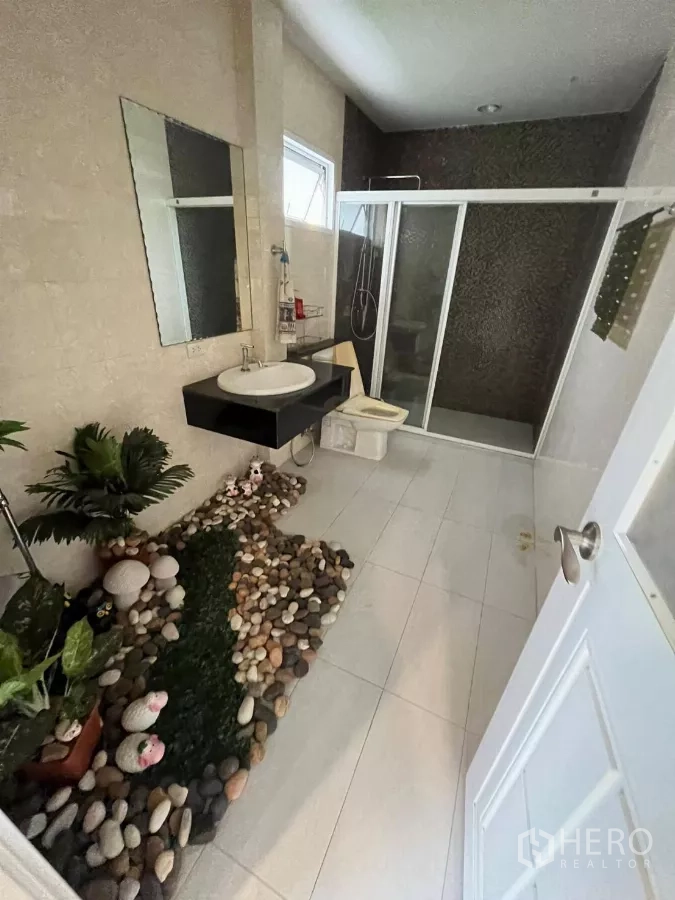 Home Office for rent in Khlong Toei, Bangkok - Bathroom featuring glass shower, vanity and decorative indoor rock garden.