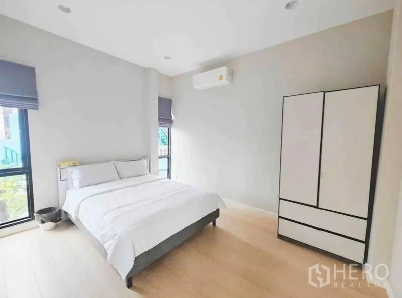 Detached House for rent - Minimalist bedroom with a queen bed, wardrobe and corner windows.