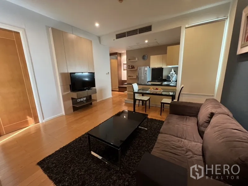 公寓 出租在Chatuchak, Bangkok - 明亮客厅配电视墙，餐桌与内置橱柜小厨房及冰箱。