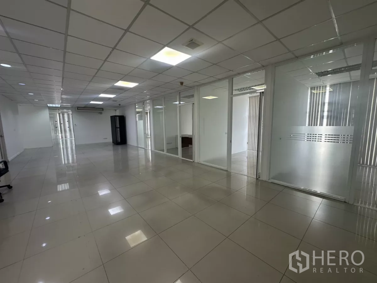 Office Space for rent in Huai Khwang, Bangkok - Large unfurnished office zone featuring multiple glass partitions and ample daylight.