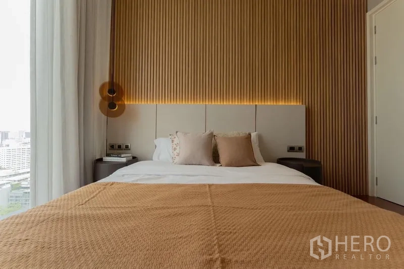 公寓 出租在Watthana, Bangkok - 次卧正面视角，木质特色墙、柔软抱枕与城市景观。