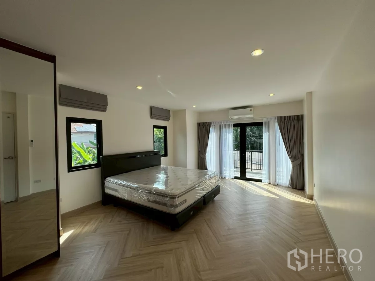 บ้าน ให้เช่าในSuan Luang, Bangkok - ห้องนอนมาสเตอร์กว้าง เชื่อมต่อระเบียง เตียงคิงส์ไซส์ และพื้นลายก้างปลา.