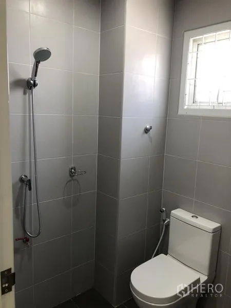 Warehouse for rent in Lat Lum Kaeo, Pathum Thani - Modern restroom with shower and toilet finished in gray tiles.