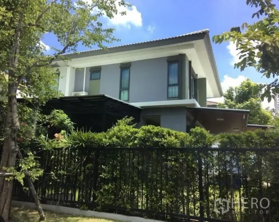 บ้าน ขาย - บ้านเดี่ยวสองชั้นสไตล์โมเดิร์น พร้อมรั้วเหล็กและพุ่มไม้เขียวชอุ่ม