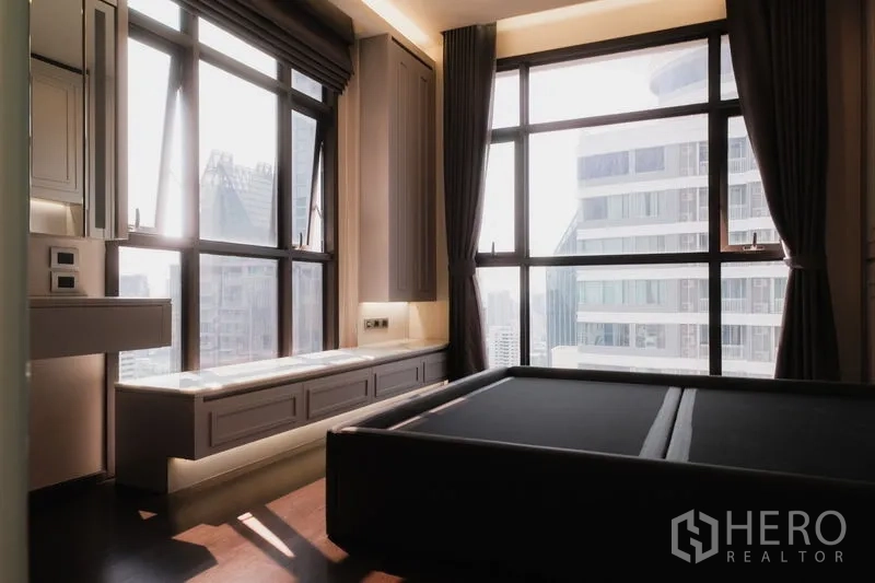Condominium for rent or sale in Watthana, Bangkok - Master bedroom with panoramic city views, large windows and built‑in bench seating.