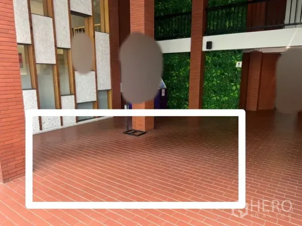 พื้นที่ขายปลีก ให้เช่า - ทางเดินอาคารมีหลังคาปูอิฐแดง เสาอิฐ ผนังแต่งลาย พร้อมพื้นที่คีออสที่ทำกรอบไว้ชัดเจน.