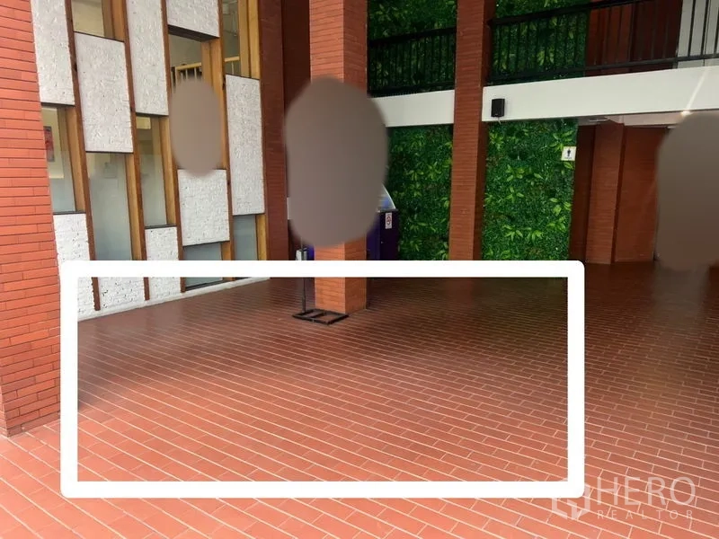 พื้นที่ขายปลีก ให้เช่า - ทางเดินอาคารมีหลังคาปูอิฐแดง เสาอิฐ ผนังแต่งลาย พร้อมพื้นที่คีออสที่ทำกรอบไว้ชัดเจน.