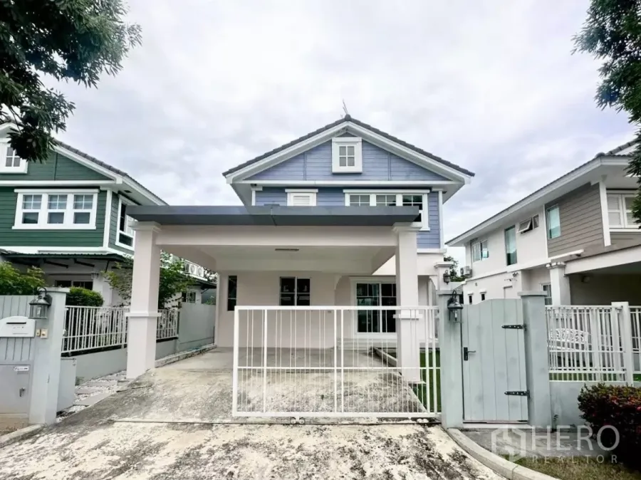 Detached House for rent in Bang Phli, Samut Prakan - Two-storey blue detached house with a covered carport and gated driveway in a modern estate.