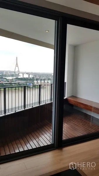Condominium for rent in Yan Nawa, Bangkok - Private balcony with wooden deck and railing looking toward the bridge.