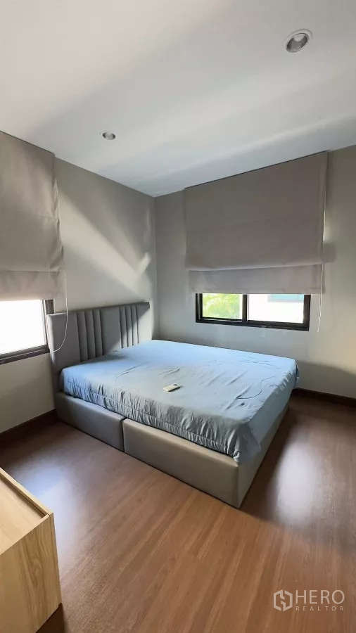 独立式住宅 出租在Samut Prakan - 次卧配两扇窗、百叶与软包床。