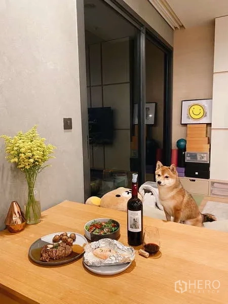 公寓 出租或出售在Chatuchak, Bangkok - 极简空间中的餐桌，旁有推拉玻璃门与内置书架。