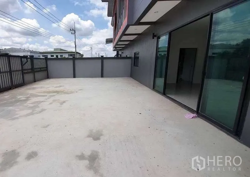 货栈 出租在Pathum Thani - 宽阔混凝土前院，可供卡车停车与装卸，旁为玻璃办公区