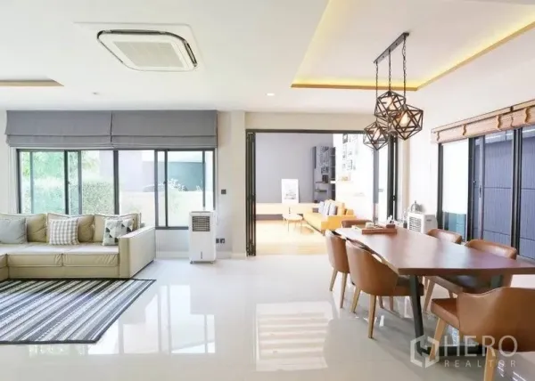 Detached House for rent or sale in Bang Kapi, Bangkok - Dining zone with geometric pendant lights opening to a family room via wide folding doors.