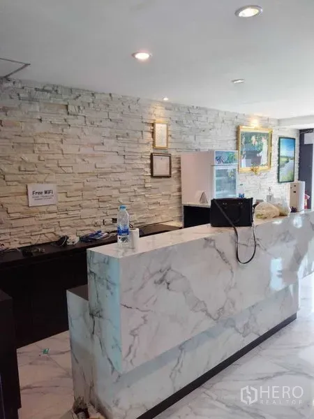 店屋 出租在Watthana, Bangkok - 大理石接待台，石纹背景墙与装饰画。