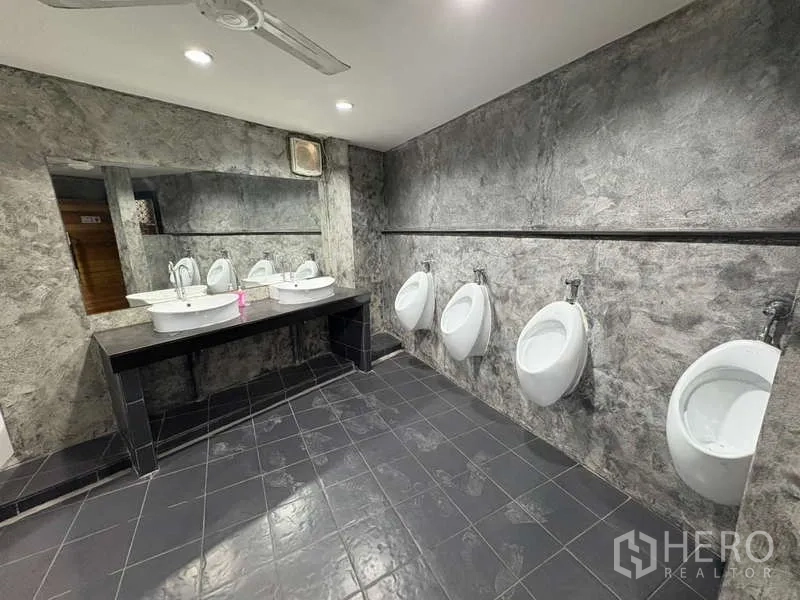 独立商业地产 出租在Khlong Toei, Bangkok - 男卫间，带小便器与双人洗手台，深色地砖。