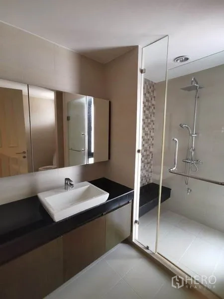 Townhouse for rent in Yan Nawa, Bangkok - Spacious bathroom with long black countertop, vessel sink, and walk-in shower.