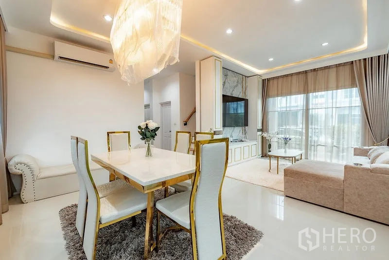 บ้าน ให้เช่าหรือขายในBang Khen, Bangkok - มุมทานอาหารพร้อมโคมไฟแขวน เครื่องปรับอากาศ และมุมมองสู่ห้องนั่งเล่นสว่าง