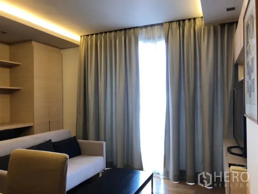 คอนโด ให้เช่าในWatthana, Bangkok - ห้องนั่งเล่นอบอุ่น โซฟา ผ้าม่านเต็มความสูง และไฟซ่อนสวยงาม