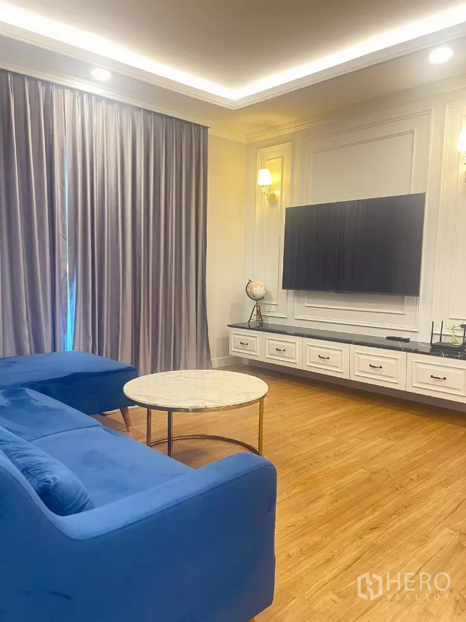 Detached House for rent in Bang Phli, Samut Prakan - Media room with blue sectional sofa, round marble tables and large TV.