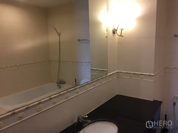 คอนโด ให้เช่าในKhlong Toei, Bangkok - ห้องน้ำพร้อมอ่างอาบน้ำ ฝักบัว และกระจกบานใหญ่เหนือเคาน์เตอร์สีดำ