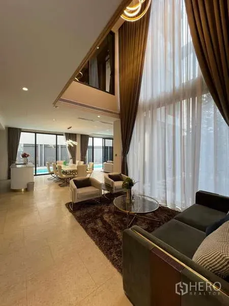 独立式住宅 出租在Suan Luang, Bangkok - 挑高客厅，落地窗与高帘，通向餐区