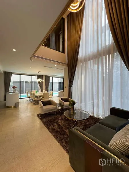 独立式住宅 出租在Suan Luang, Bangkok - 挑高客厅，落地窗与高帘，通向餐区