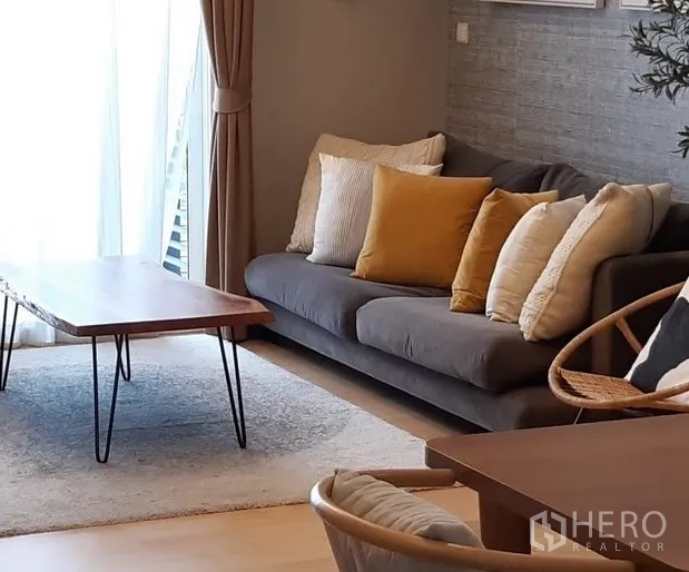 คอนโด ให้เช่าในKhlong Toei, Bangkok - ห้องนั่งเล่นสว่าง โซฟาสีเทาพร้อมหมอนสีเหลือง โต๊ะไม้ และผ้าม่านสูงจรดเพดาน ในคอนโดใกล้ BTS ทองหล่อ
