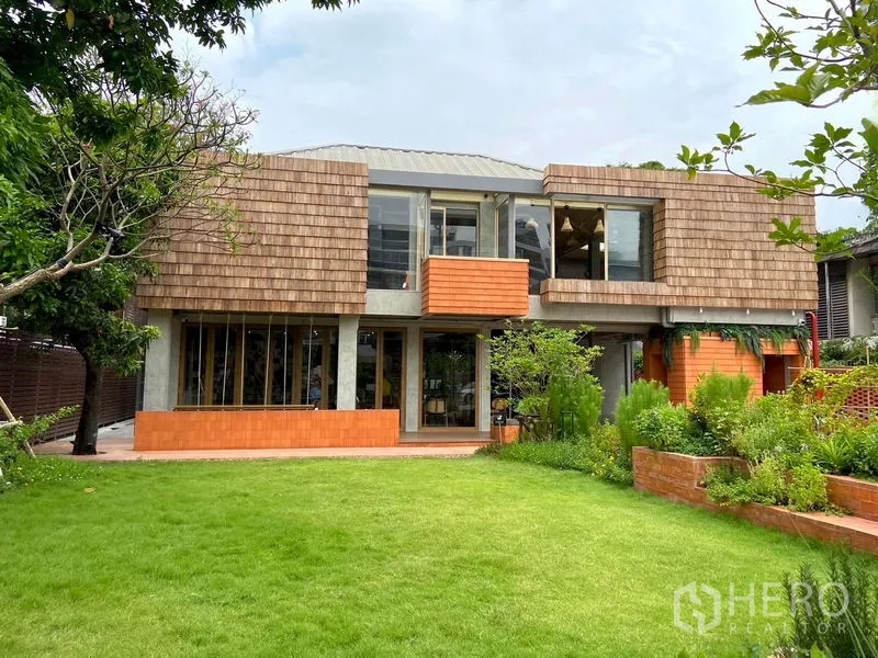 พื้นที่ขายปลีก ให้เช่าในWatthana, Bangkok - อาคารพาณิชย์สองชั้นสไตล์ร่วมสมัย หน้าจั่วไม้ชิงเกิล พร้อมสนามหญ้าและสวนเขียวขจี