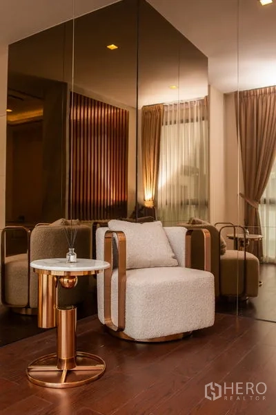 独立式住宅 出租或出售在Bangkok - 休闲单椅与大理石边几，前方为落地镜墙。