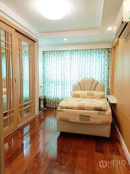 คอนโด ให้เช่าในWatthana, Bangkok - ห้องนอนขนาดกะทัดรัด เตียงเดี่ยว ตู้เสื้อผ้าบานเลื่อนกระจกเงา ผ้าม่าน และพื้นไม้.