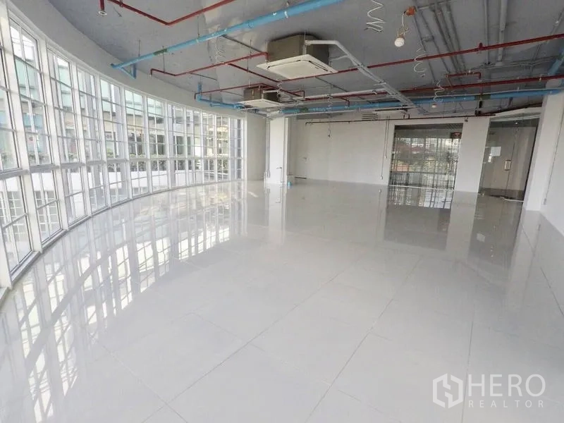 零售空间 出租在Khlong Toei, Bangkok - 采光充足的展厅式室内，环绕落地窗、瓷砖地与管道空调。