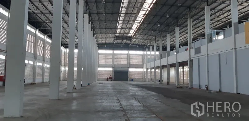 Factory for rent in Lat Krabang, Bangkok - Central aisle of the factory hall with skylight roofing and tall pillars.