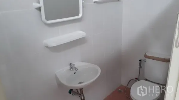 货栈 出租在Lam Luk Ka, Pathum Thani - 仓库内洁净瓷砖卫生间，配洗手盆、镜子、置物架和坐便器带喷枪。