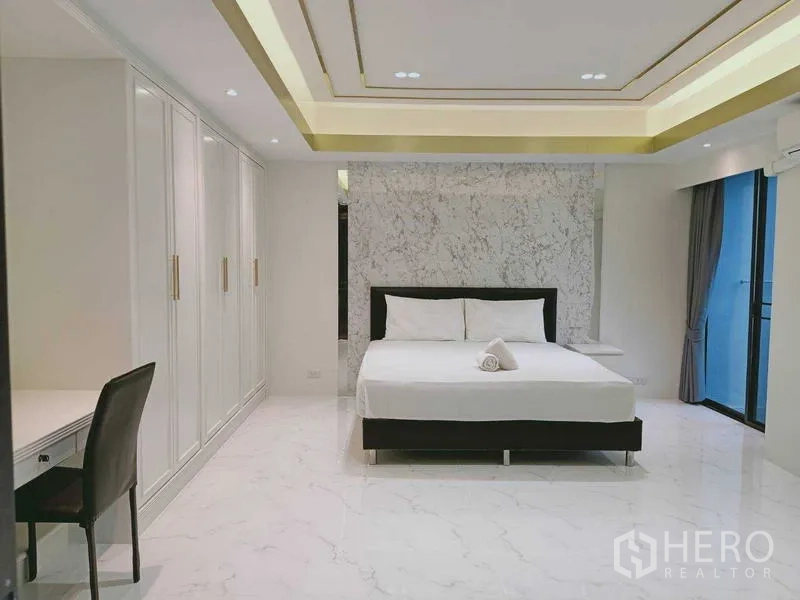 Condominium for  in Watthana, Bangkok - Bedroom with marble headboard wall, built-in wardrobes and balcony access.