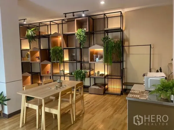 零售空间 出租在Khlong Toei, Bangkok - 温馨角落，带灯展示架、木质餐桌椅与备餐台小电器。