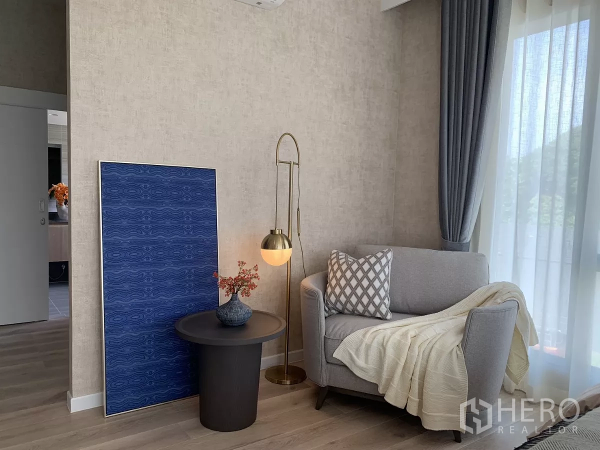 Detached House for rent in Bang Kapi, Bangkok - Reading nook with armchair, floor lamp, side table and blue artwork.