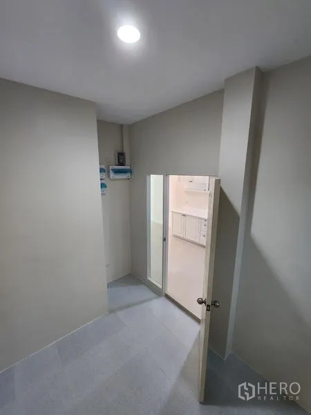 Townhouse for rent in Wang Thonglang, Bangkok - Compact entry area with recessed light and a door opening toward a bright kitchen zone.