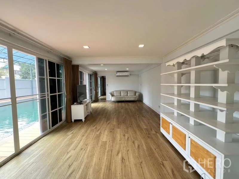 Detached House for rent in Bang Phli, Samut Prakan - Long family room with built-in shelving and sliding glass doors to the pool deck.