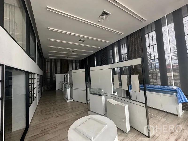 พื้นที่ขายปลีก ให้เช่าในBang Phli, Samut Prakan - แกลเลอรีค้าปลีกพร้อมหน้าต่างกรอบดำสูงและชุดตู้แสดงสีขาว