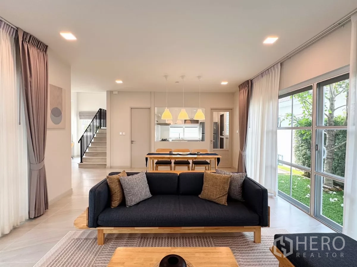 Detached House for rent in Bang Phli, Samut Prakan - View from the lounge toward dining area and staircase with floor-to-ceiling glass to the lawn.