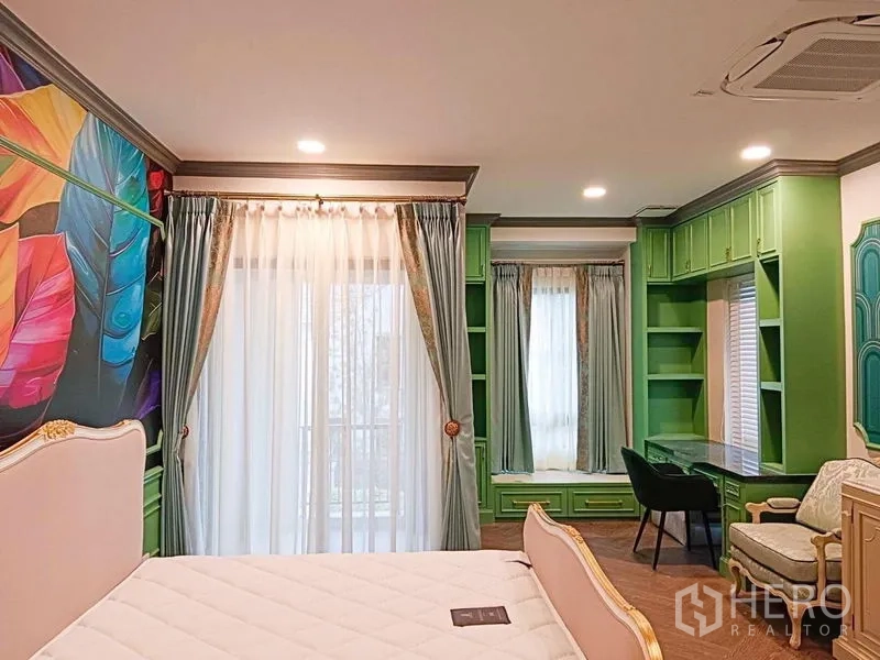 Detached House for rent or sale in Saphan Sung, Bangkok - Bedroom with built-in green cabinetry, study desk and balcony door.